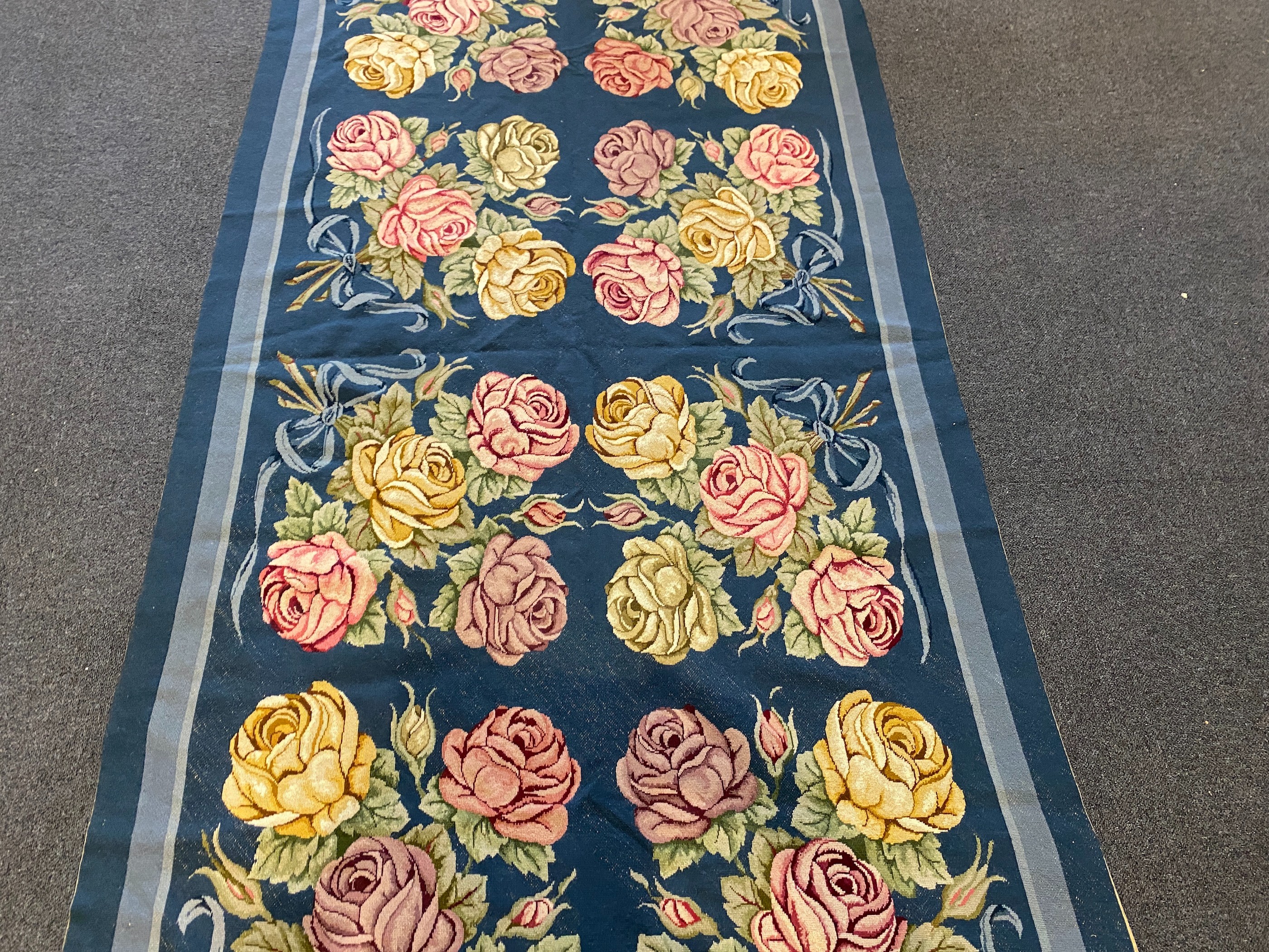 An English needlepoint blue ground carpet, 252 x 125cm